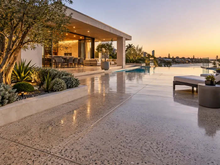 Sealed outdoor concrete paving surrounding a modern swimming pool and alfresco entertaining area